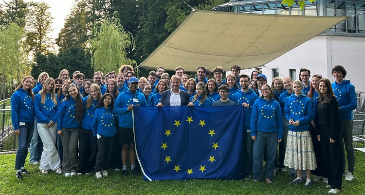 Gruppenfoto der Teilnehmenden in EU-Hoodies mit Europaflagge im Vordergrund